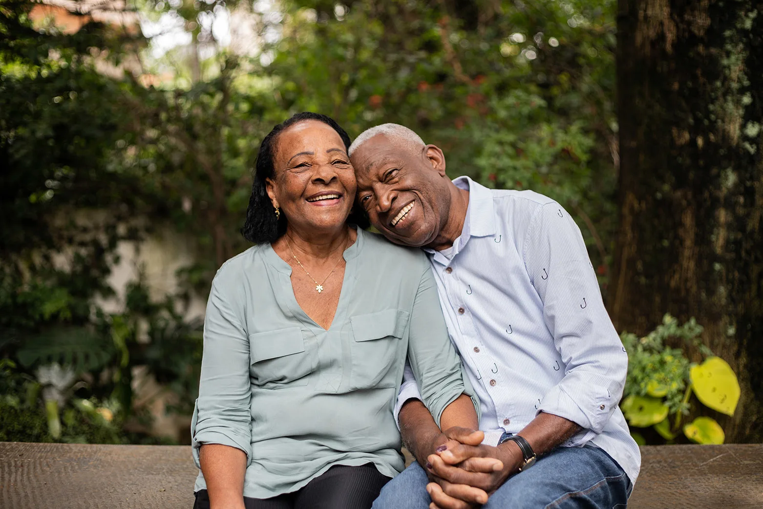 A smiling senior couple sitting together outdoors, representing retired UNITE HERE members enjoying their pension benefits.